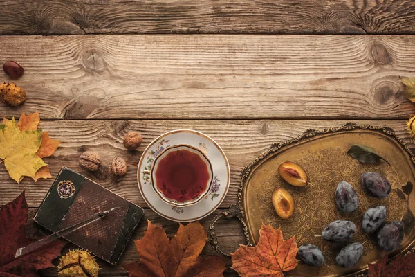 Сливы, орехи и листья с классическим ноутбуком и чай с эффектом пленка фильтра горизонтальной — стоковое фото